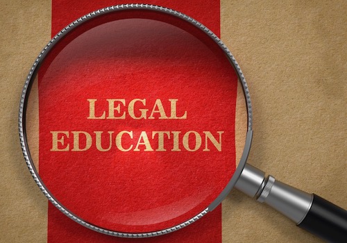 Picture of a Magnifying Glass over the Phrase Legal Education on a Red Background