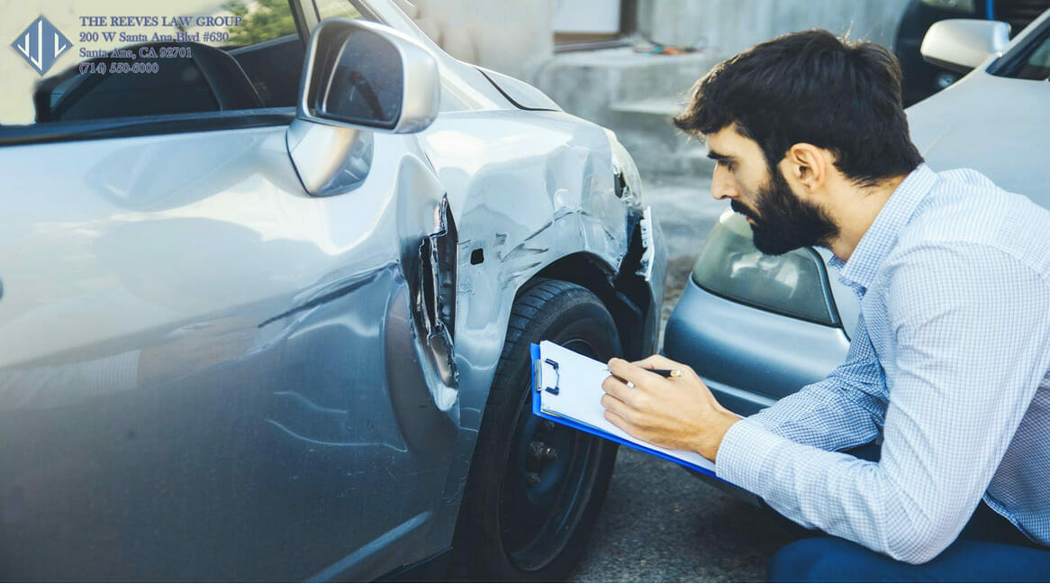 car accident aftermath man holding clipboard with damaged car and mirror