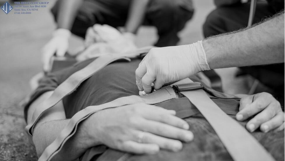 man lying on street with straps and paramedic hands first aid bangage gray