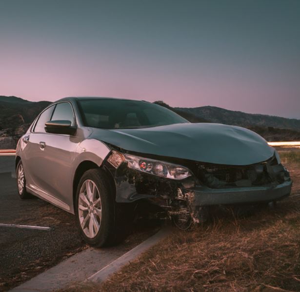 damaged car on the side of the road in the twlight location riverside ca